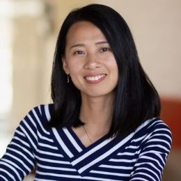 Female data science student smiles while posing in the translational research center lobby.